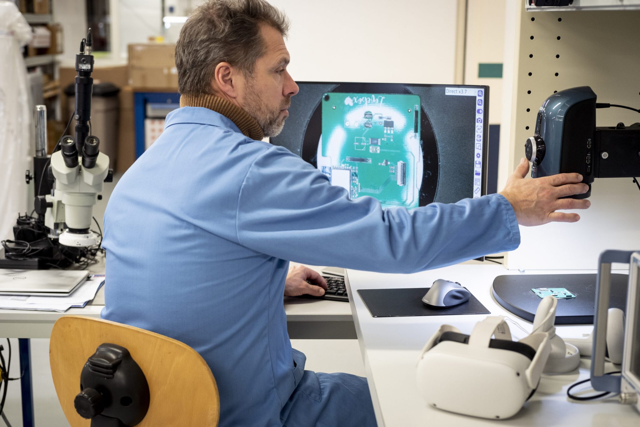 Un personne en train de travailler avec sur son bureau un casque de réalité virtuelle