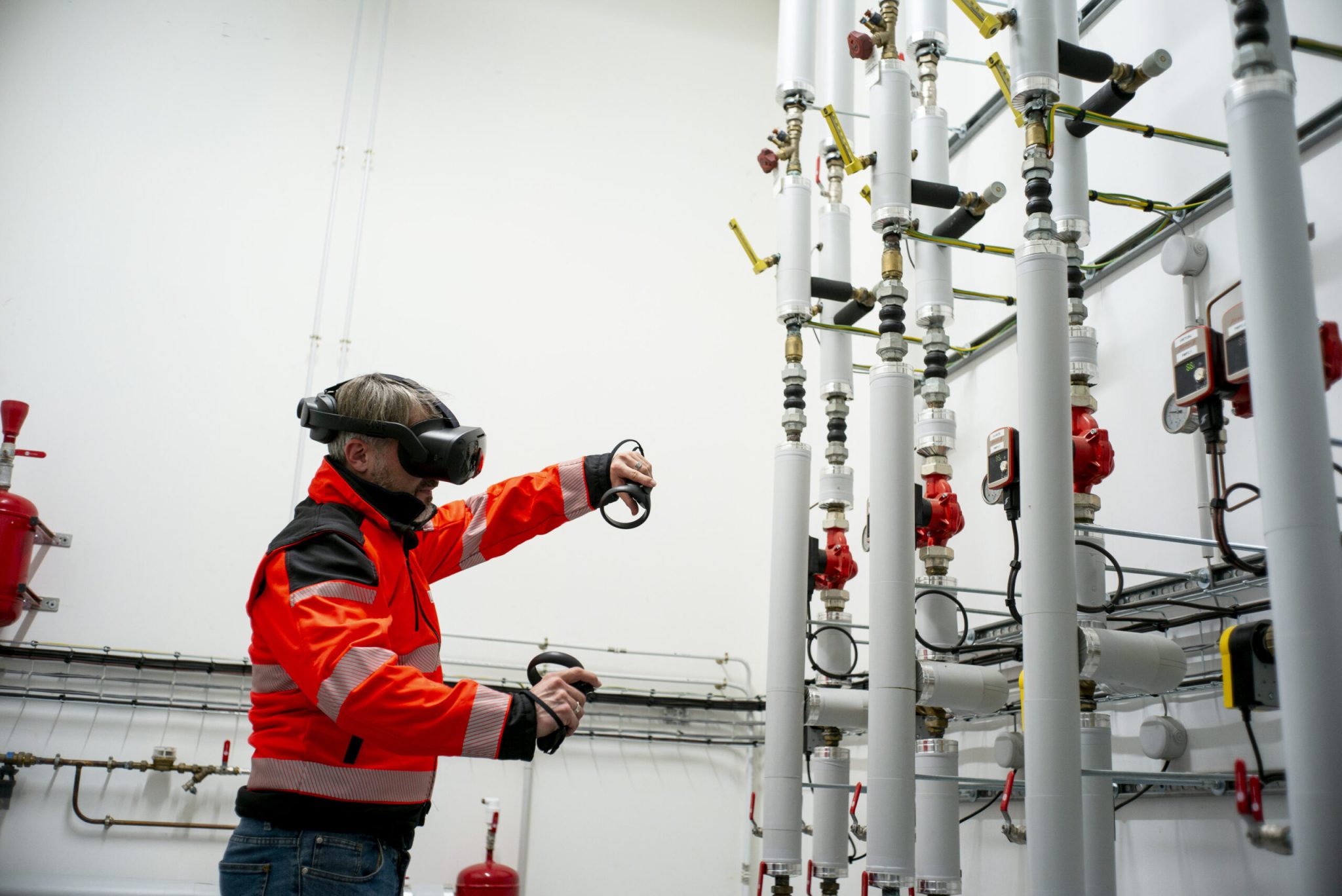 Une personne avec un casque de réalité virtuelle et deux manettes en train de regarder en détails les informations de la chaudière
